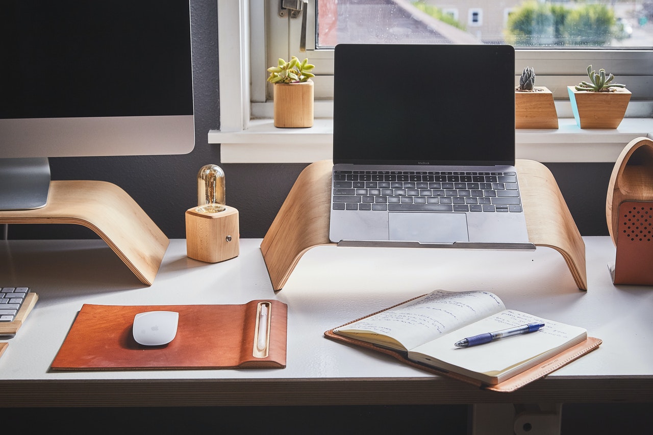Work from home set up with desktop, laptop, mouse and journal